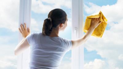 Young woman washing windows