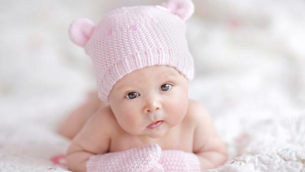 newborn baby girl in pink knitted bear hat