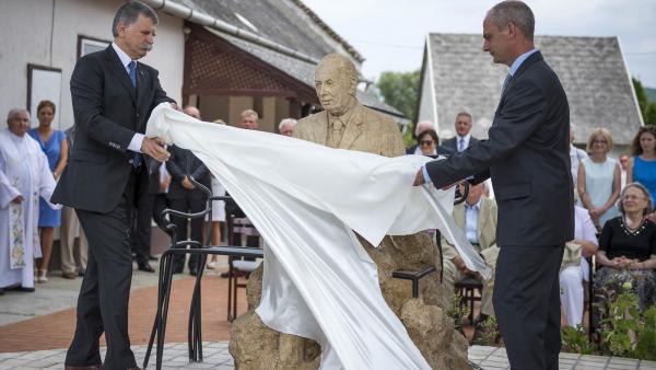 Bánd, 2016. július 31.
Kövér László, az Országgyûlés elnöke (b) és Steigerwald Zsolt polgármester leleplezi Mádl Ferenc szobrát, Gácsi Barna alkotását a Veszprém megyei Bándon, az egykori köztársasági elnök szülõfalujában 2016. július 31-én.
MTI Fotó: B