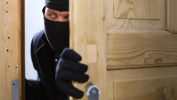 Security - disguised burglar breaking in an apartment or office to steal something