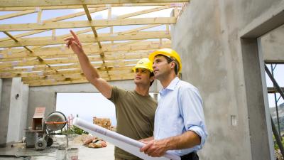 Workers with blueprints in structure