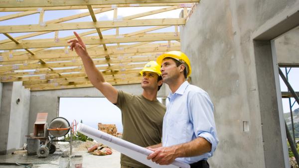 Workers with blueprints in structure