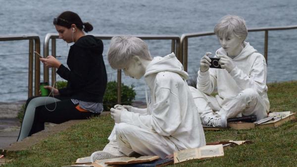 Egy nő mobiltelefonját használja Fabio Pietrantonio Quotidianity, the brothers (Hétköznapiság, a fivérek (2103)) című alkotása mellett az évente megrendezett tengerparti szoborkiállításon Sydney Bondi Beach és Bronte Beach közötti partszakaszán. (MTI/EPA/