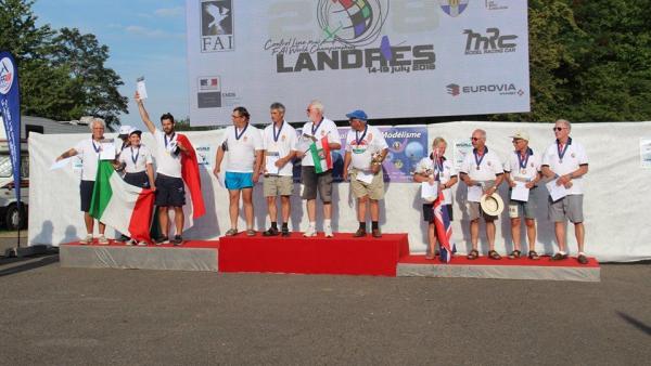 A dobogó legfelső fokán Csoma György (B), mellette Elekes Imre, a zászlót Szvacsek Ferenc tartja, jobboldalt a csapatkapitány Travnik István, második az olasz, harmadik az angol csapat (fotó: Gyula Televízió)

