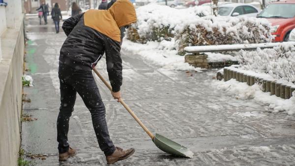 Egy férfi havat lapátol a Szabadság téren 2018.12.15.-én. Fotó: behir.hu/Varga Diána