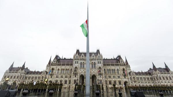 Katonai tiszteletadás mellett felvonják, majd félárbócra engedik Magyarország nemzeti lobogóját az Országház előtti Kossuth Lajos téren az 1956-os forradalom és szabadságharc leverésének 63. évfordulóján, a nemzeti gyásznapon (Fotó: MTI/Mohai Balázs)