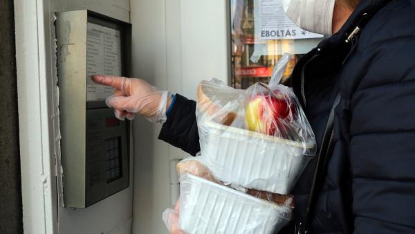 Illusztráció: a koronavírus-járvány miatt a Miskolci Egyesített Szociális, Egészségügyi és Gyermekjóléti Intézmény munkatársa idős emberekhez csenget be, akiknek ebédet visz 2020. március 20-án. Fotó forrás: MTI/Vajda János