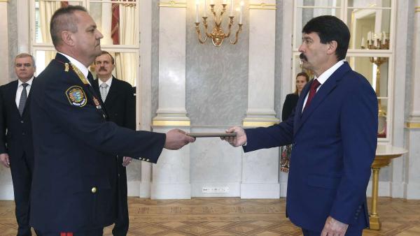 Áder János köztársasági elnök átadja a tűzoltó dandártábornoki kinevezést Kiss András Zoltán tűzoltó ezredesnek a Sándor-palota Tükörtermében 2020. április 27-én. A háttérben Szabó István, a Honvédelmi Minisztérium (HM) honvédelmi ügyekért felelős államti