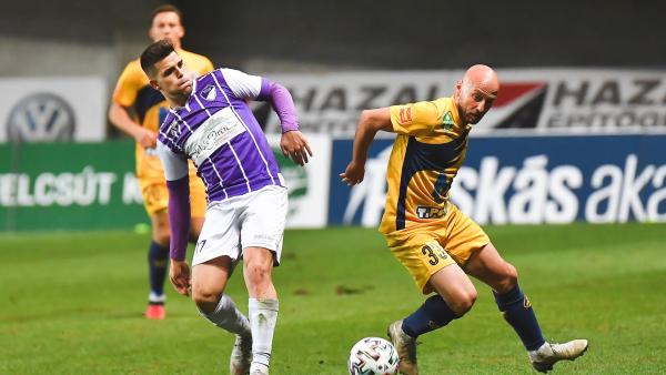 Ilyés Tamás (lilában) passzolja el a labdát Varga József mellett – (Fotó: pfla.hu)