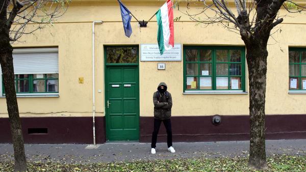 Egy maszkos fiatalember az ex Füge Klub előtt – Fotó: behir.hu/Such Tamás