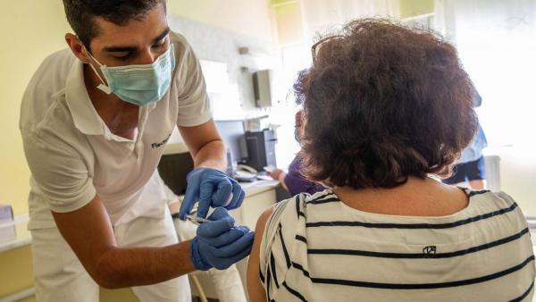 Megyeri Zoltán ápoló beolt egy nőt a Pfizer-BioNTech koronavírus elleni oltóanyagának első adagjával a Békés Megyei Központi Kórház Dr. Réthy Pál Tagkórházának egyik oltópontján Békéscsabán 2021. március 14-én. MTI/Rosta Tibor