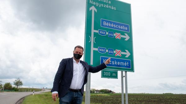 Dankó Béla az egyik útjelző tábla mellett